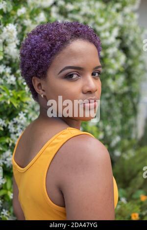 Vertical portrait of young woman with purple colored hair Stock Photo