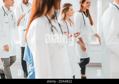 large group of medical professionals striding through the hospital lobby Stock Photo