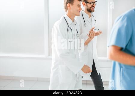 large group of medical professionals striding through the hospital lobby Stock Photo