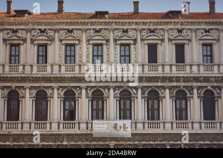 Venetian windows and architectural elements in the façade of a characteristic palace full of decorations. Pattern of windows and historic decorations. Stock Photo