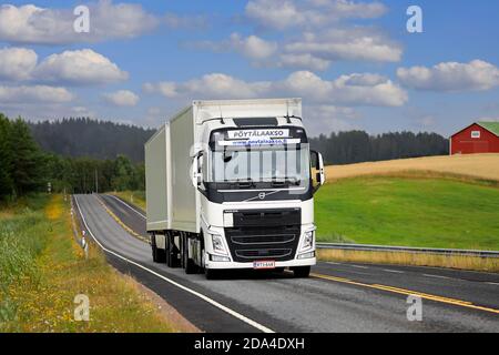 White Volvo FH truck pulls semi trailer on highway E63 on a beautiful ...