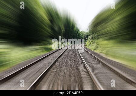 double-track railroad railway or train tracks with speed motion blur - fast travel concept background with copy space Stock Photo