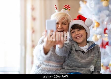 Mother and son taking selfie by Christmas tree Stock Photo