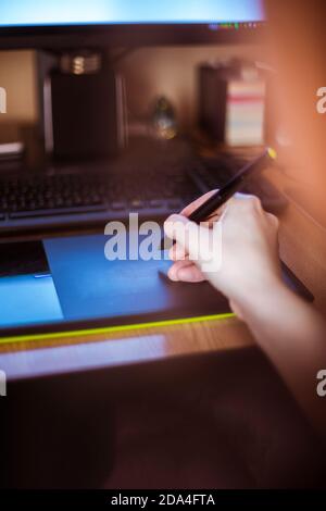 Graphic design works on a computer graphics tablets, pen tablet. Focus on graphic tablet. Stock Photo