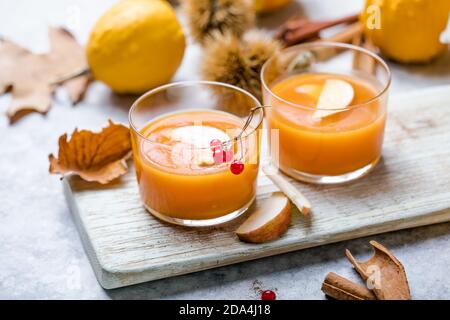 hot pumpkin punch or sangria in a glass with apple. Halloween and Thanksgiving beverage. Traditional autumn, winter drinks and cocktails Stock Photo