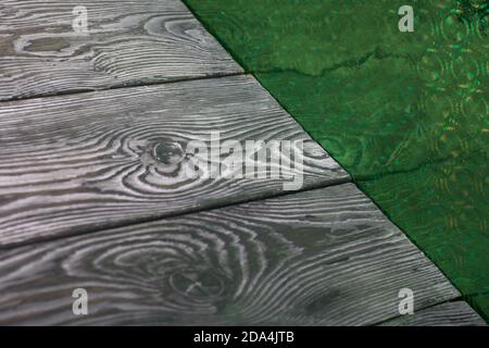 Brushed pine boards painted black and white. The iridescent surface is green. Stock Photo
