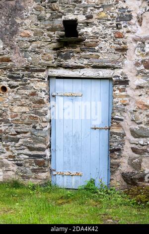 An old wooden door in a traditional stone farm building at Lowpark in the English Lake District near Loweswater, Cumbria UK Stock Photo
