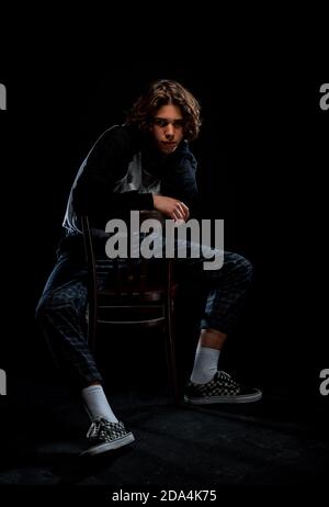 Portrait of a trendy guy wearing turtleneck jumper, checkered pants and stylish sneakers Stock Photo