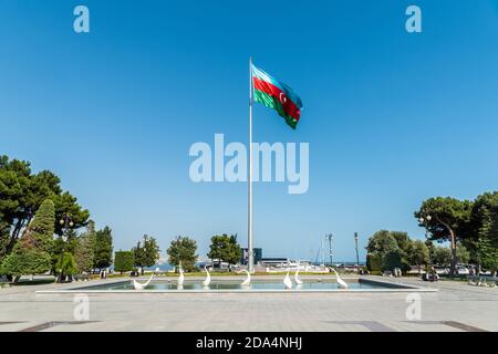 Baku, Azerbaijan – August 2, 2020. Pond with swan sculptures and national flag of Azerbaijan on the seaside boulevard in Baku. Stock Photo