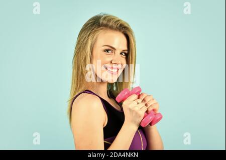 Always in good shape. coach dressed in sport clothes. muscular woman in  training pumping up muscles of hands. girl use barbell blue background.  girl doing triceps exercise with dumbbell in the gym Stock Photo - Alamy