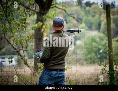Back view of a young male launches a drone into the sky Stock Photo