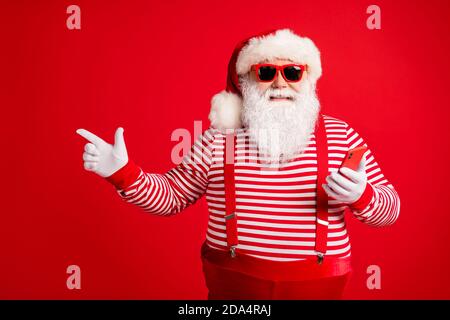 Portrait of his he nice handsome cheerful bearded fat overweight Santa using device app 5g showing copy space shopping gift present surprise isolated Stock Photo