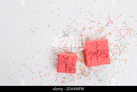 Lots of Christmas gifts in big and small boxes, confetti scattered around on a white isolated background Stock Photo