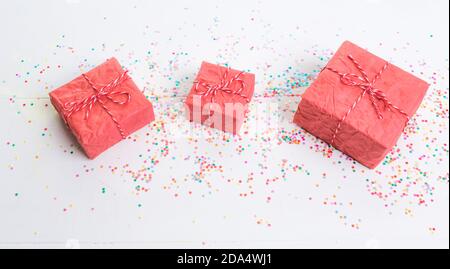 Lots of Christmas gifts in big and small boxes, confetti scattered around on a white isolated background Stock Photo