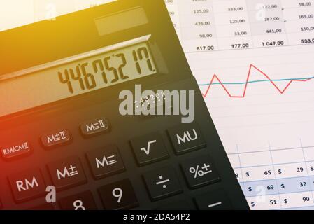 Close-up of a calculator on a desktop with graphs. Financial statements. Online payment of bills, calculation of household finances, taxes. Family Stock Photo