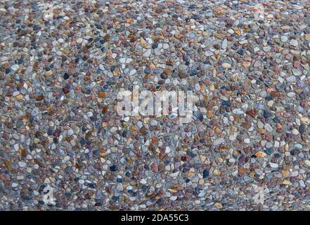 texture of stones in a light-colored concrete fence, crushed stone Stock Photo