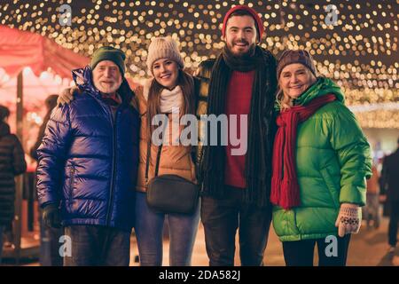 Portrait of nice attractive cheerful family meeting embracing traveling spending time visiting festal street market newyear gathering tradition Stock Photo