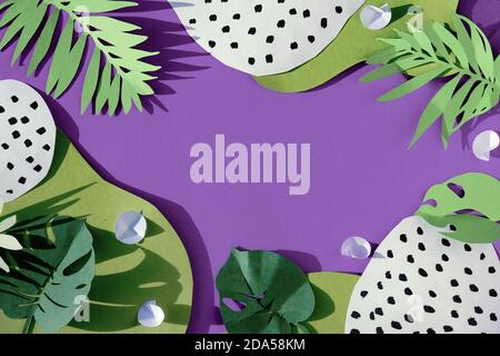 Palm and monstera leaves and spotted abstract shapes on pink paper background, frame with copyspace. Stock Photo