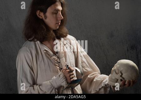 Young man holding human skull Stock Photo - Alamy