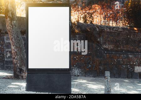 A template of an empty vertical advert banner with a stone wall behind; the mockup of a blank advertising poster in suburban settings; a mock-up of a Stock Photo