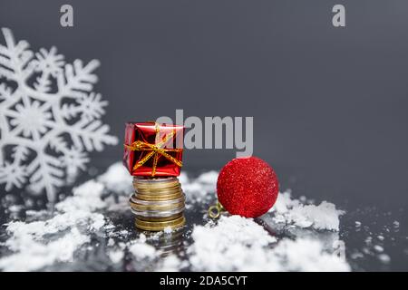 coins, christmas ball, small gifts on gray blurred background, christmas decoration  Stock Photo