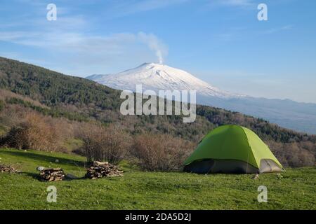 green tent on meadow of Nebrodi Park in front of Etna Mount, Sicily Stock Photo