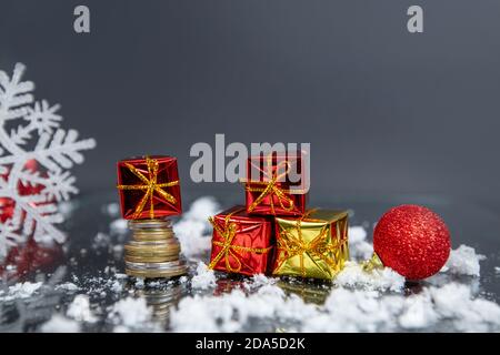coins, christmas ball, small gifts on gray blurred background, christmas decoration  Stock Photo