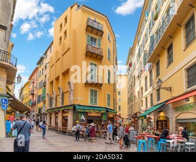 Tourists gather at one of the many sharp corners and turns in the twisty, winding Old Town of Vieux Nice, France, on the French Riviera Stock Photo