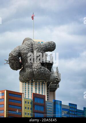 Surreal Rear view of replica of King Kong climbing a building while holding a bi-lane at tourist attraction in Gatlinburg, TN Stock Photo