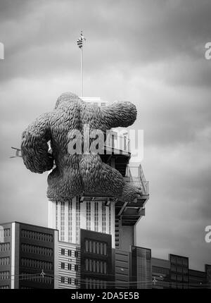 Surreal Rear view of replica of King Kong climbing a building while holding a bi-lane at tourist atttaction in Gatlinburg, TN, in black and white Stock Photo