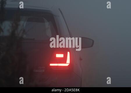Tail lights of a car in thick fog, blue hour, foggy evening, foggy night, fog, car Stock Photo