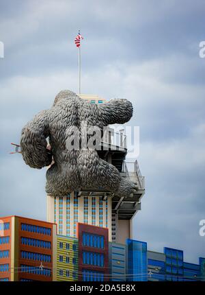 Surreal rear view of replica of King Kong climbing a building while holding a bi-lane at tourist attraction in Gatlinburg, TN Stock Photo