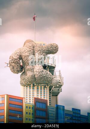 Surreal Rear view of replica of King Kong climbing a building while holding a bi-lane at tourist atttaction in Gatlinburg, TN Stock Photo