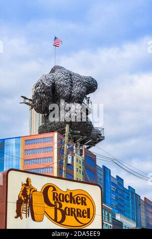 Surreal, rear view of replica of King Kong climbing a building in front of signboard advertising the Cracker Barrel restaurant in Pigeon Forge, TN Stock Photo