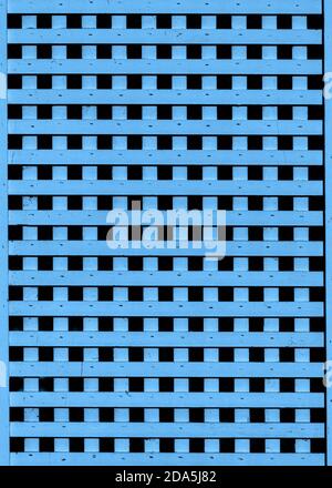 Wooden blue slats form abstract repeating grid pattern on facade of old building Stock Photo