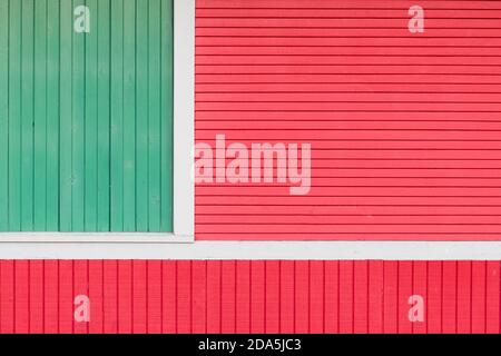 Green and red wooden slats form abstract pattern of lines on facade of old building Stock Photo