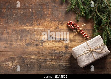 christmas rustic greeting card. Christmas gift box, candy cane with fir tree and blank greeting card over rustic wooden background. Christmas and New Stock Photo