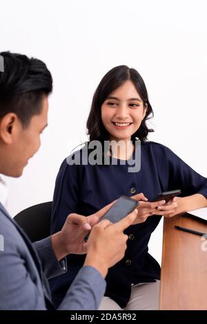 portrait of a business partner who is chatting business work and working using a laptop or cellphone. On modern office desk Stock Photo