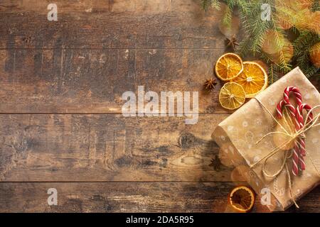 Christmas rustic flat lay. Stylish christmas frame of pine branches, cones, oranges, thread, anise on rural. Candy cane, design. Copy Space for text Stock Photo