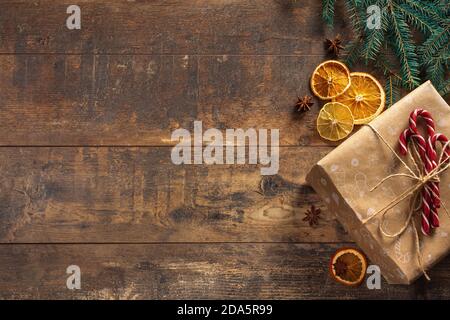 Christmas gift on wooden background. Frame from decorated Christmas tree on rustic wooden background with copy space for text. Happy New Year concept. Stock Photo
