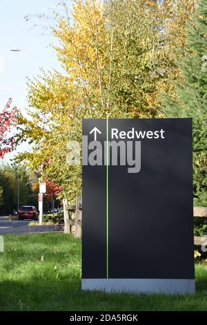 Big black sign on grass next to the street showing direction to Microsoft Redwest campus in Redmond, Washington, USA. Taken in Autumn. Stock Photo