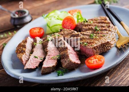 Grilled juicy steak medium rare beef with spices and fresh salad. Stock Photo