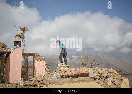 Rasuwa, Nepal, January 2016. People working on their homes destroyed by the April 2015 earthquake. Stock Photo