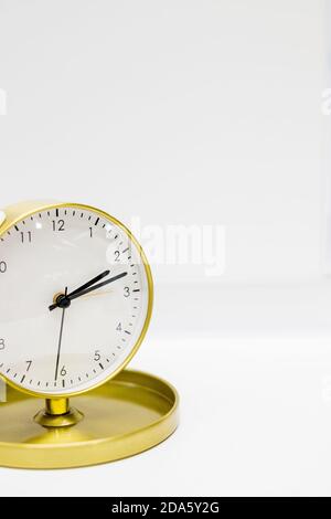Old alarm clock with ten minutes past two. Date and time reminder or deadline concept, small clock on white background, counting down to holiday Stock Photo