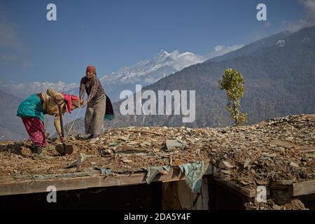 Rasuwa, Nepal, January 2016. People working on their homes destroyed by the April 2015 earthquake. Stock Photo