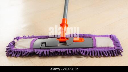 mop with a rag close-up on light linoleum Stock Photo