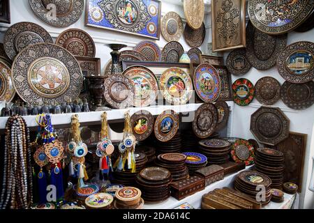 Souvenir plates and carved boxes on shelves in a souvenir shop in Tashkent. 04.29.2019. Stock Photo