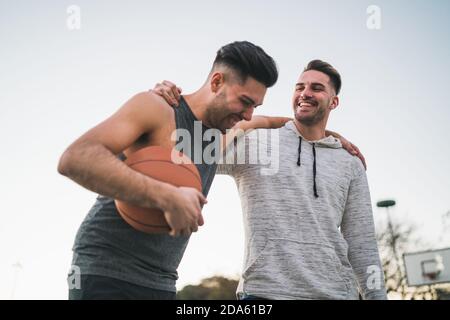 Two young friends playing basketball. Stock Photo
