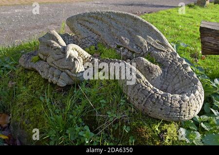 A large stone garden ornament of a sleeping dragon Stock Photo