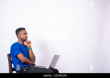 young african man thinking about something while using his laptop Stock Photo